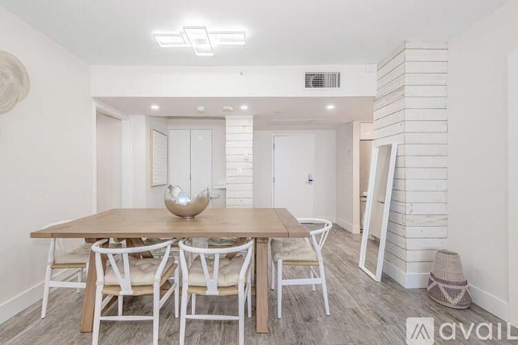 A dining room with a wooden table and chairs.