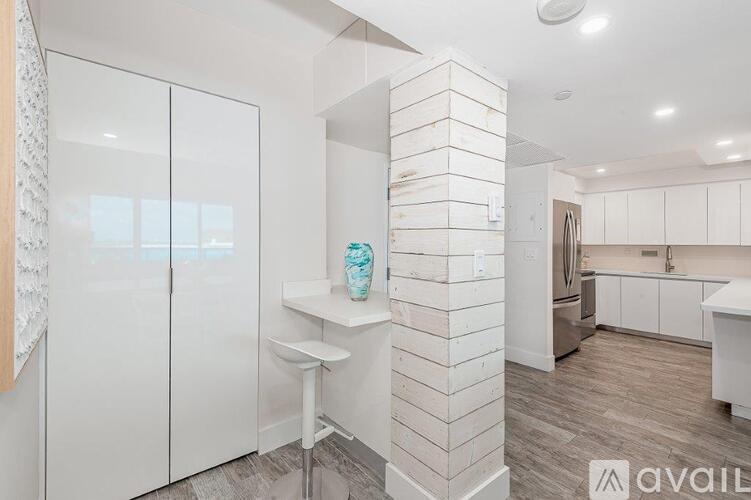 A kitchen with white cabinets and a white countertop.