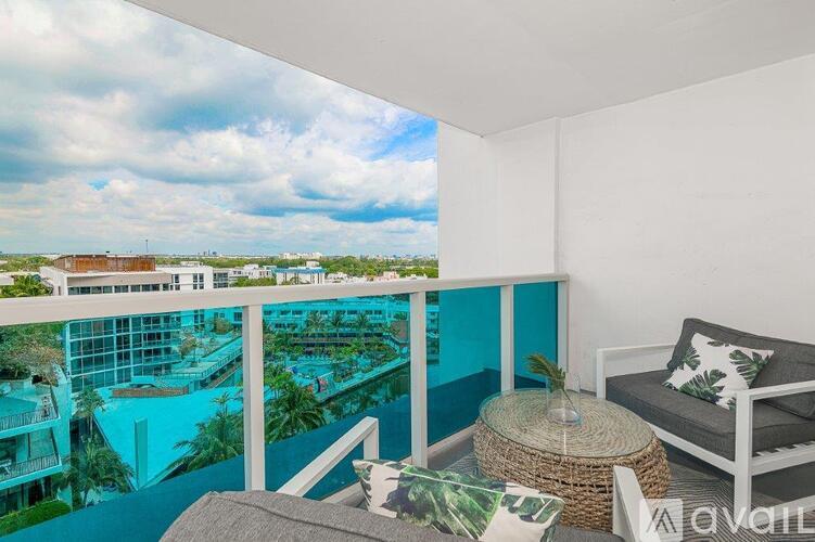 A balcony with a view of a pool and buildings.