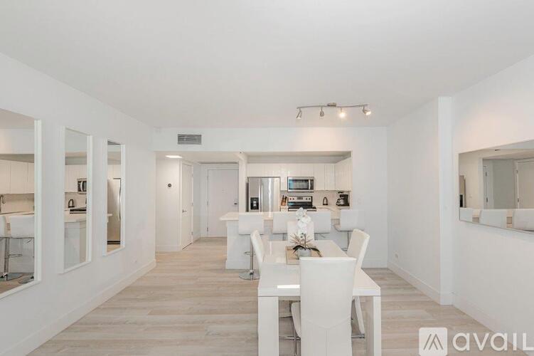 A white dining room with a long table and chairs.