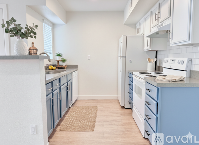 A kitchen with white cabinets and blue countertops.