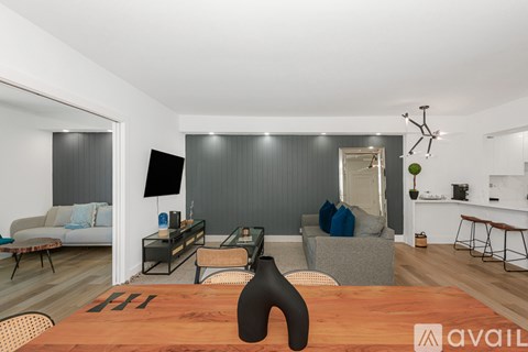 A modern living room with a wooden table and a black vase on it.