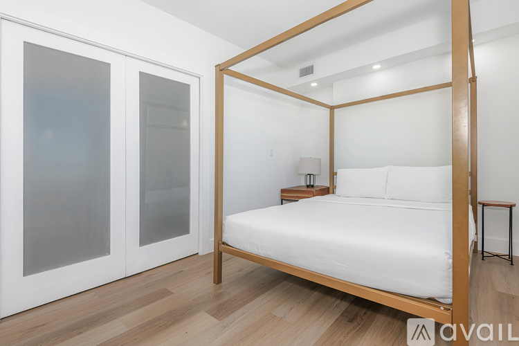 A bedroom with a four poster bed and a nightstand.