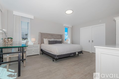 A bedroom with a bed, nightstand, and chair.