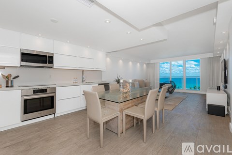 A modern kitchen with a dining table set for four.