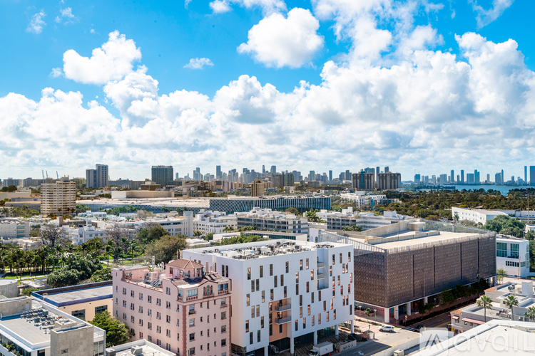 A cityscape with a mix of modern and older buildings under a blue sky with clouds.