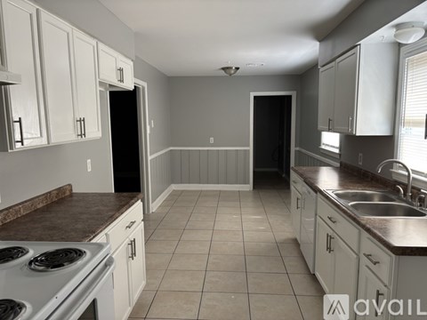 A kitchen with white cabinets and a brown countertop.