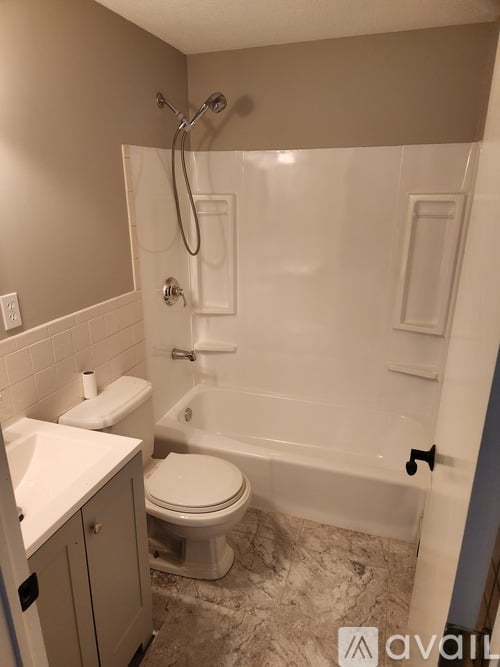 A bathroom with a toilet, sink, and bathtub.