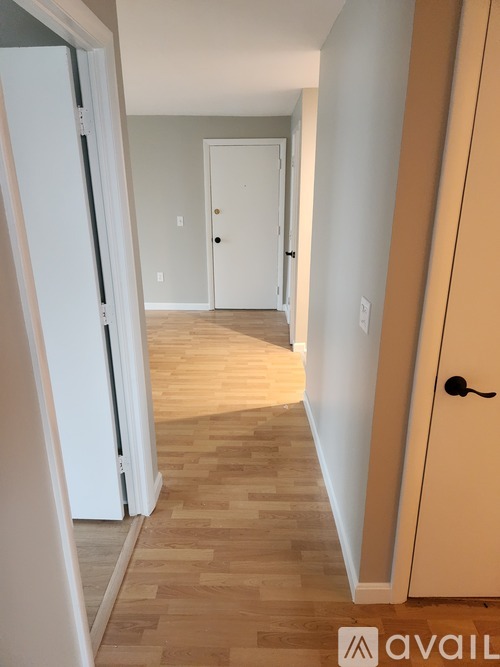 A hallway with a white door and a brown door.