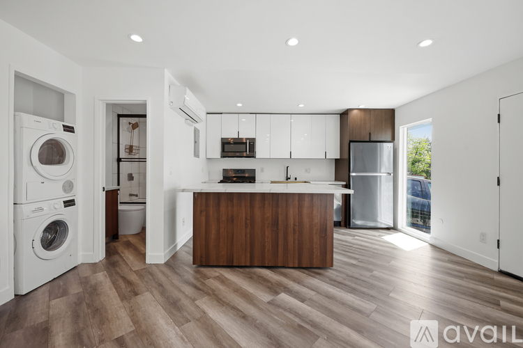 A modern kitchen with a wooden island and white appliances.