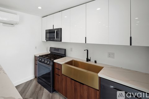 A kitchen with a black stove top oven and a black microwave above it.