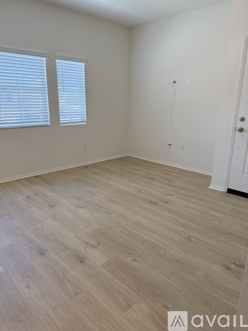A room with wooden flooring and a white door.