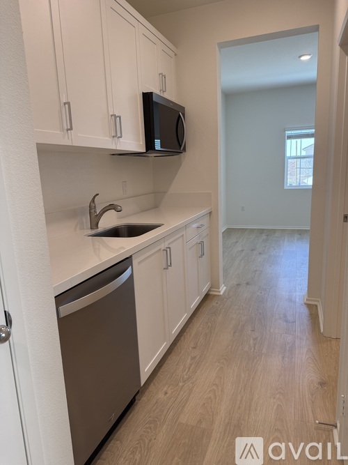 A kitchen with white cabinets and a stainless steel dishwasher.