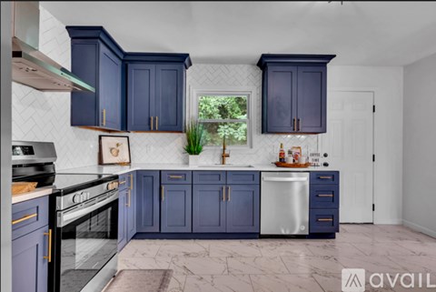 A kitchen with dark blue cabinets and a white tiled backsplash.