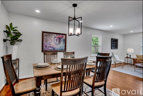 A dining room with a wooden table and chairs.