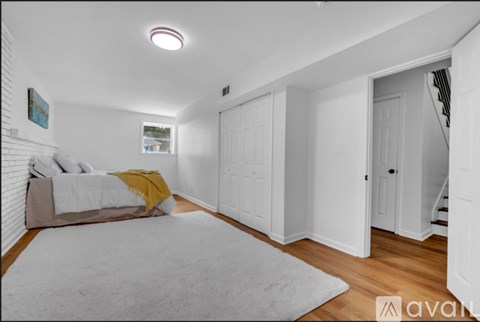 A bedroom with a bed and a rug in the foreground.