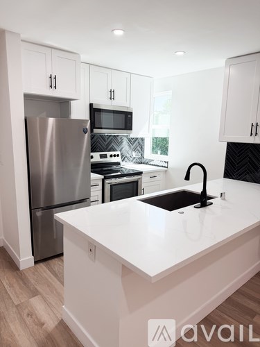 A kitchen with a white countertop and stainless steel appliances.