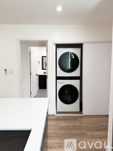A modern laundry room with a washer and dryer built into the wall.