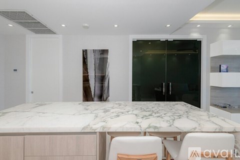 A modern dining area with a marble table and chairs.