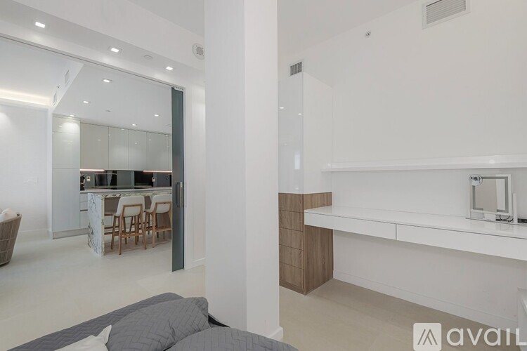 A modern kitchen with white cabinets and a dining table with chairs.