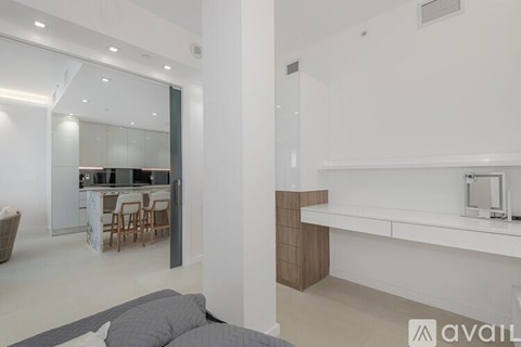 A modern kitchen with white cabinets and a dining table with chairs.
