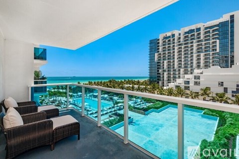 A balcony with chairs and a pool overlooking a cityscape.