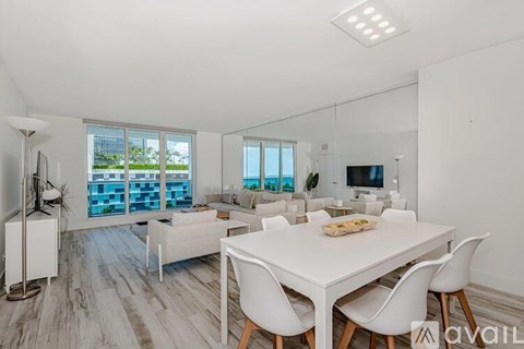 A modern dining room with a white table and chairs.