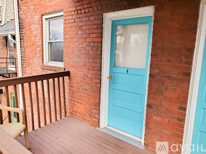 A blue door is on the right side of a brick building.