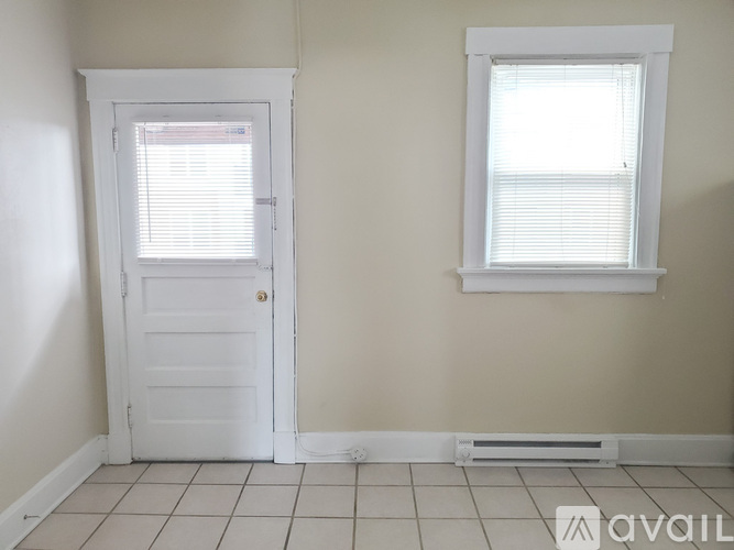 A room with a white door and a window with blinds.