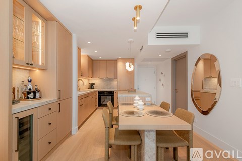 A modern kitchen with wooden cabinets and a dining table.