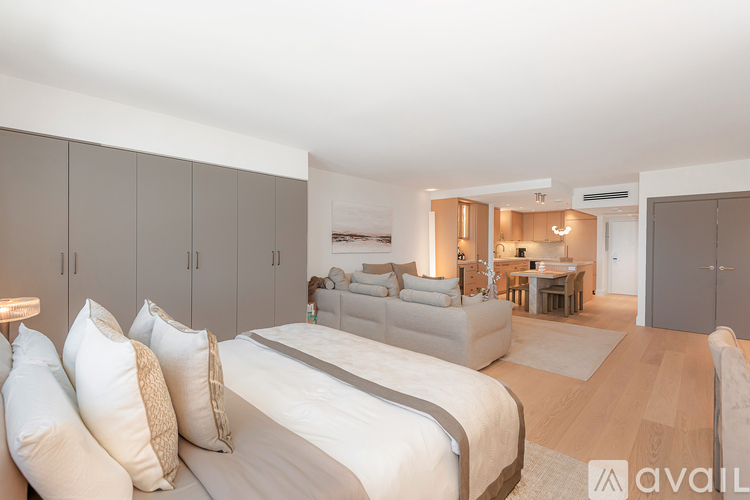 A bedroom with a large bed and a couch in the background.