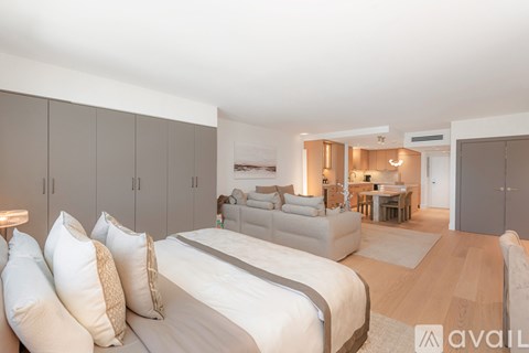 A bedroom with a large bed and a couch in the background.
