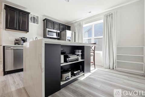 A modern kitchen with dark wood cabinets and stainless steel appliances.