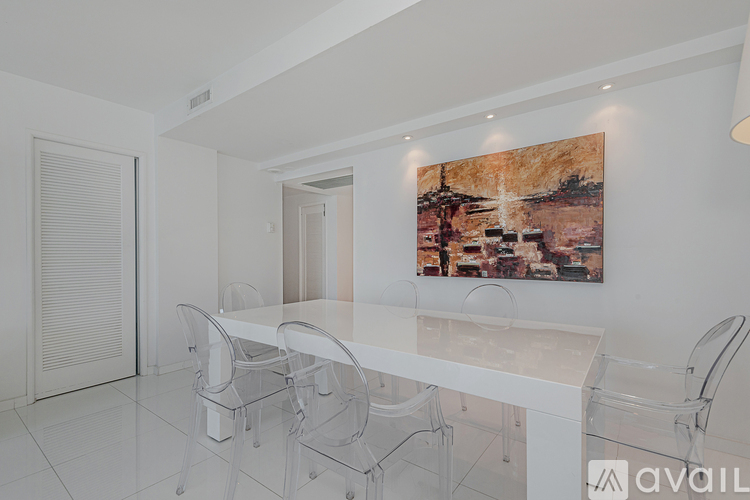 A white dining room with a table and chairs.