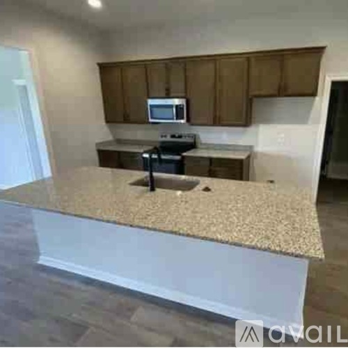 A kitchen with a granite countertop and wooden cabinets.