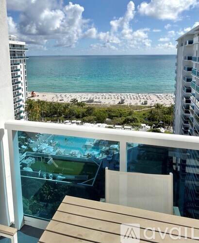 A balcony with a view of the ocean and a pool.