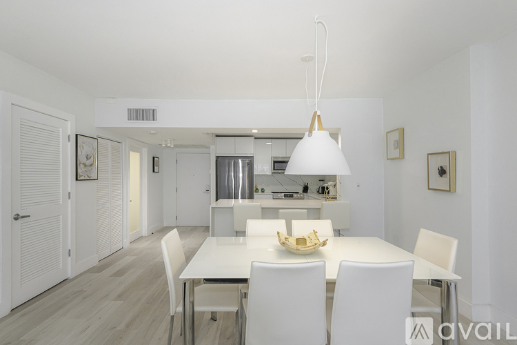 A modern dining room with a white table and chairs.