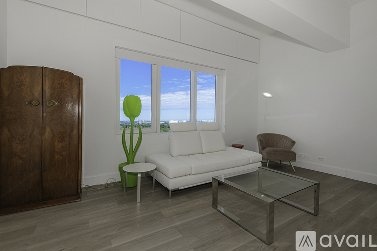A living room with a white sofa, a glass coffee table, and a wooden cabinet.