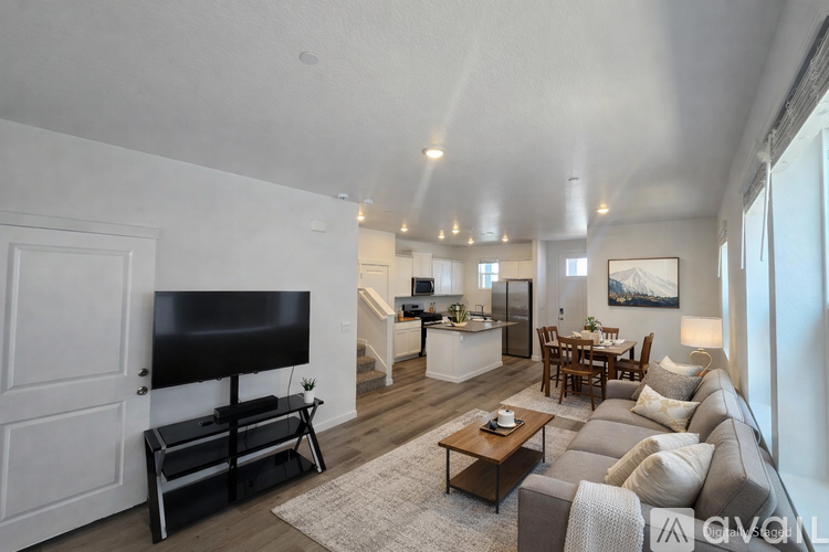 A living room with a grey couch and a black television.