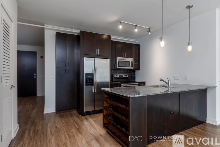 A kitchen with dark wood cabinets and a granite countertop.