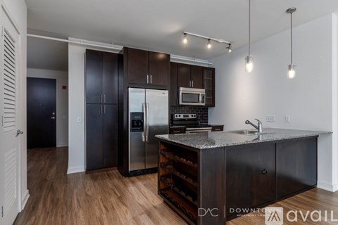 A kitchen with dark wood cabinets and a granite countertop.