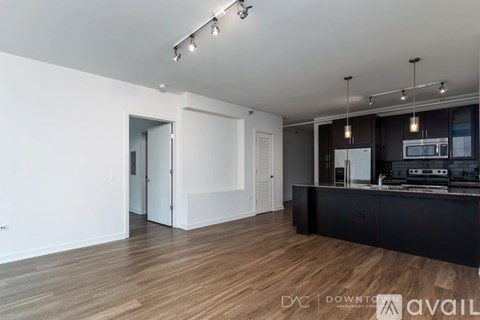 A modern kitchen with a wooden floor and white walls.