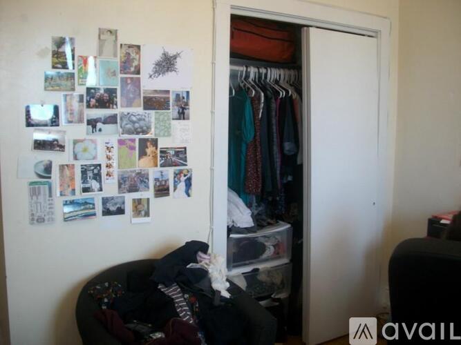A room with a wall covered in photos and a closet with clothes.