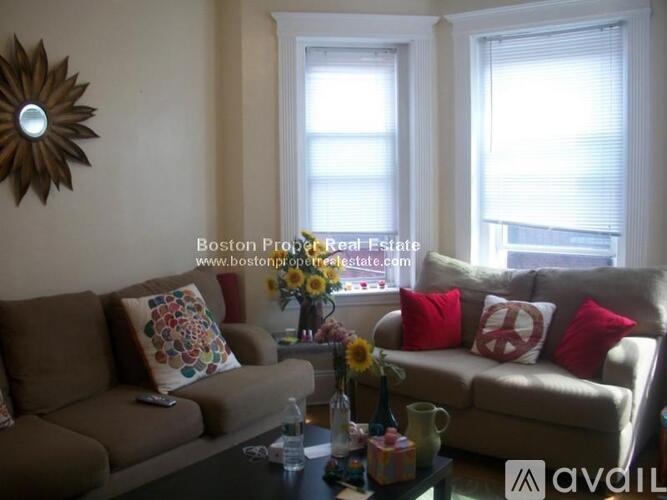 A living room with a couch, a coffee table, and a mirror on the wall.