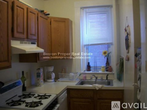 A kitchen with wooden cabinets and a stove top oven.