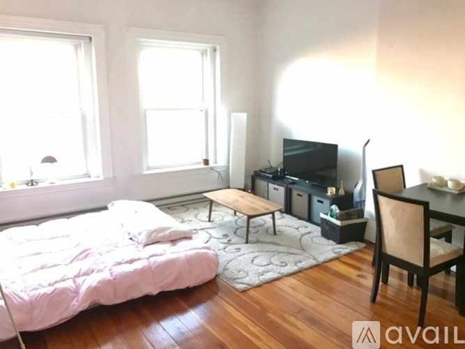 A bedroom with a bed, a chair, and a television.
