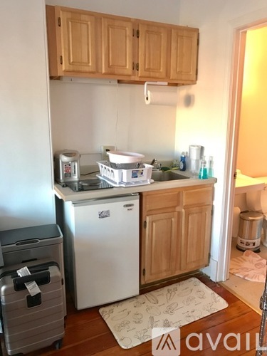 A kitchen with wooden cabinets and a white dishwasher.