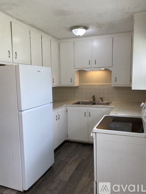 A kitchen with white appliances and cabinets.
