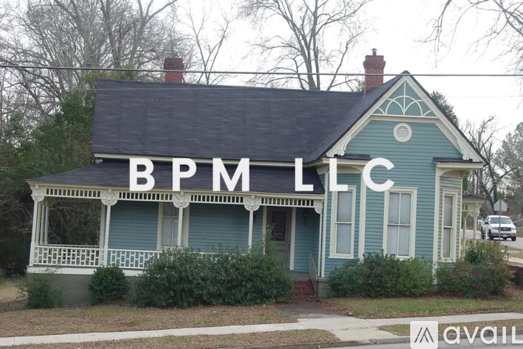 A blue house with the letters BPM LLC on the roof.