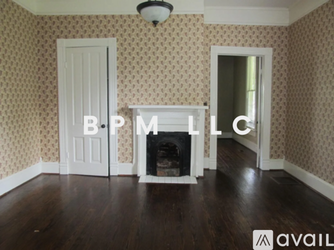 A room with a fireplace and a wallpapered wall.